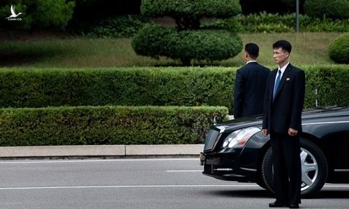 Hai vệ sĩ đứng gác bên cạnh một chiếc xe limousine của lãnh đạo Triều Tiên. Ảnh: AFP. 