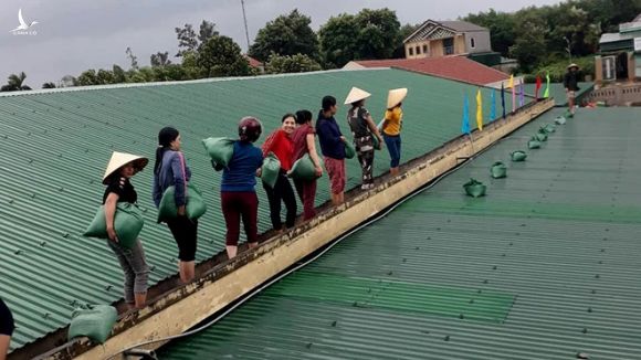 Các nữ giáo viên mầm non đưa bao tải cát lên mái nhà để gia cố phòng học /// Ảnh Tân Kỳ