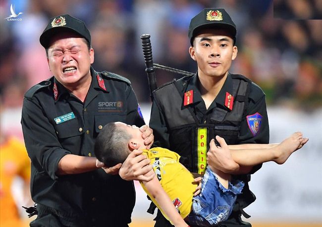 Hình ảnh cảnh sát cơ động sơ cứu trẻ bị động kinh trên sân Thiên Trường (Nam Định).  