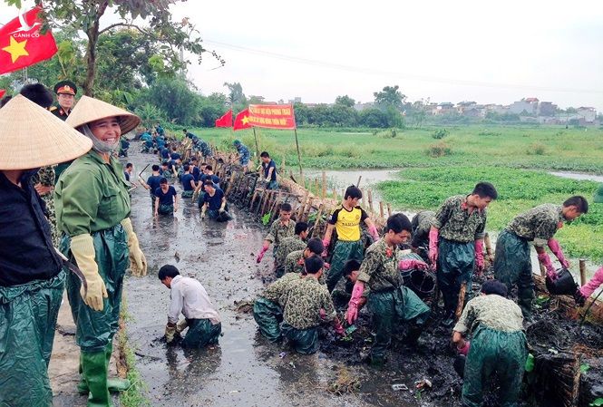 Bộ đội Đặc công tham gia giúp dân làm sạch kênh mương, cải tạo môi trường trên địa bàn huyện Thanh Trì, Hà Nội. Ảnh: Hồng Lương