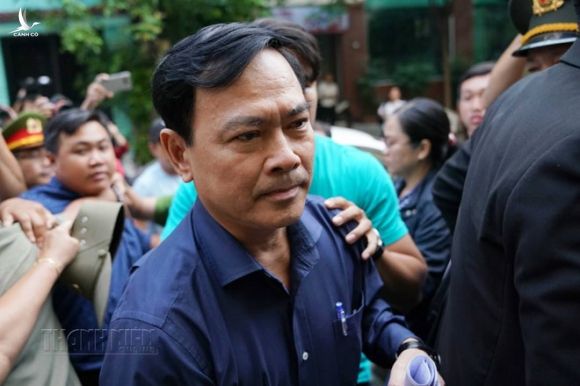Bị cáo Nguyễn Hữu Linh mặc áo sơ mi, quần tây đến tòa cùng luật sư trên chiếc ô tô /// ẢNH: ĐỘC LẬP