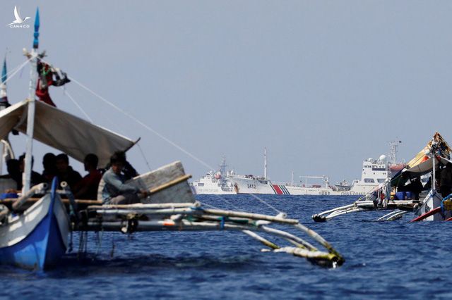 Thuyền banca chèo tay của ngư dân Philippines tại bãi cạn Scarborough. Xa xa là các tàu công vụ của Trung Quốc.