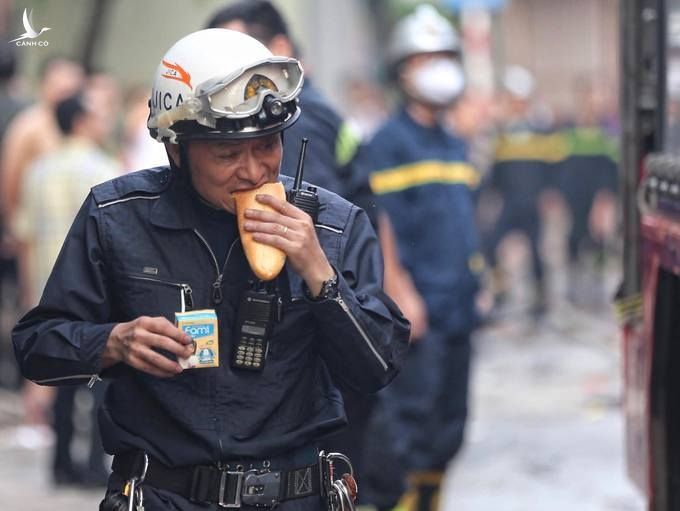 Anh lính cứu hỏa ăn tạm bánh mỳ lúc sáng sớm để có sức tiếp tục nhiệm vụ.