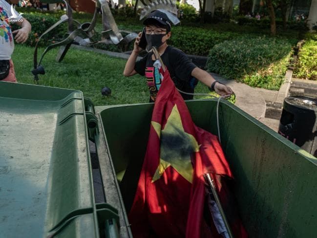 Một người biểu tình ném lá cờ Trung Quốc vào thùng rác ở quận Shatin. Ảnh: Getty