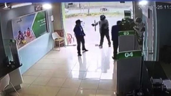 Hình ảnh trung úy công an cầm súng đe dọa và bắn bị thương bảo vệ ngân hàng /// ẢNH CẮT TỪ CLIP