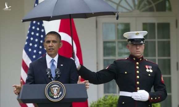 Một lính thủy đánh bộ Mỹ che ô cho tổng thống Barack Obama khi ông phát biểu tại Nhà Trắng hồi năm 2015. Ảnh: AFP.