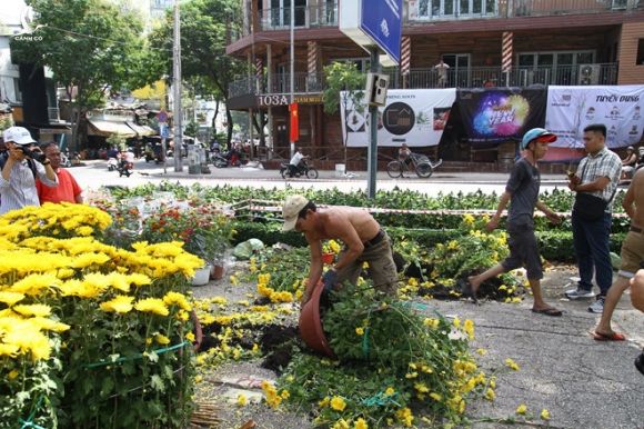 Cảnh đập bỏ hoa vào xế chiều 30 tết tại khu vực chợ hoa xuân công viên 23.9 (Q.1, TP.HCM) /// Ảnh: Phạm Hữu