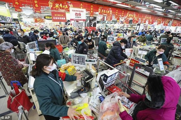 Người dân bên trong Vũ Hán bận rộn mua sắm chuẩn bị Tết và cả mua thiết bị ngăn lây nhiễm virus corona. Ảnh: AP