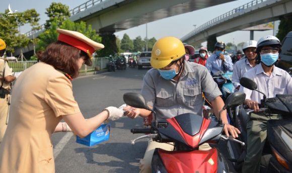 Giữa trưa, CSGT phát khẩu trang y tế cho người dân ở cửa ngõ Tân Sơn Nhất - Ảnh 5.