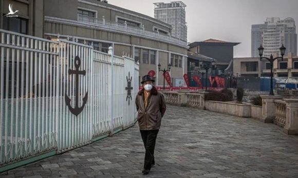 Người đàn ông đeo khẩu trang đi bộ bên ngoài trung tâm mua sắm Solana vắng tanh ở Bắc Kinh hôm 12/2. Ảnh: Washington Post.