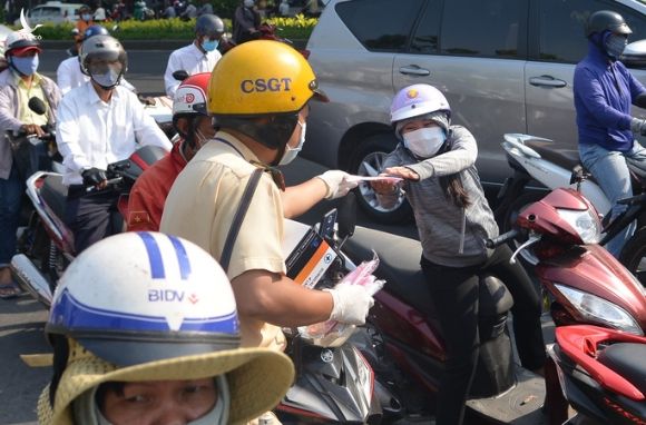 Giữa trưa, CSGT phát khẩu trang y tế cho người dân ở cửa ngõ Tân Sơn Nhất - Ảnh 3.