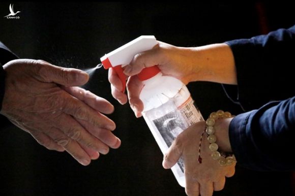 Một người được phun thuốc vệ sinh bàn tay phòng COVID-19 trước khi vào Đền Lũng Sơn ở thành phố Đài Bắc, Đài Loan ngày 12.3