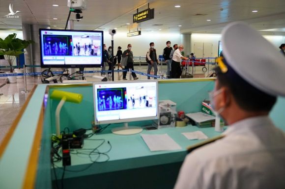Lực lượng chức năng kiểm tra thân nhiệt hành khách sau khi đáp xuống sân bay Tân Sơn Nhất /// Ảnh: Độc Lập
