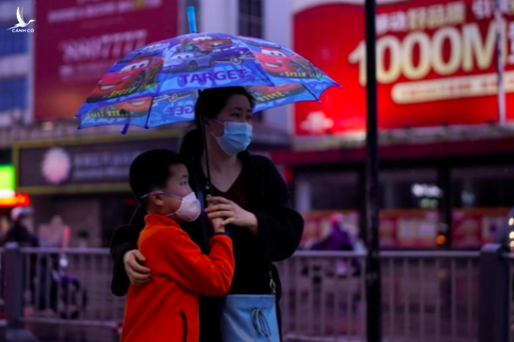 Người dân di chuyển trên đường phố Kinh Châu hôm 26/3, khi lệnh phong toả được nới lỏng ở tỉnh Hồ Bắc. Ảnh: Reuters
