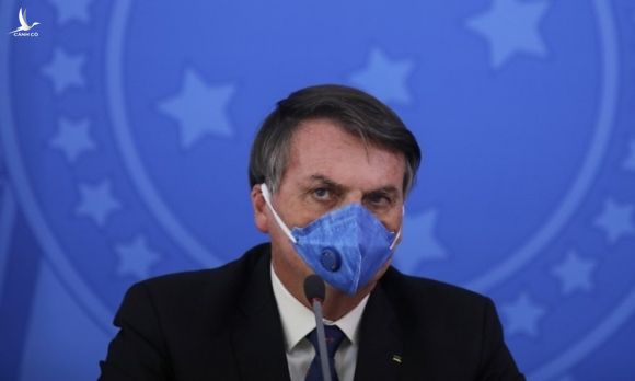 Tổng thống Brazil Bolsonaro đeo khẩu trang trong cuộc họp báo về Covid-19 tại Brasilia hôm 20/3. Ảnh: AFP.