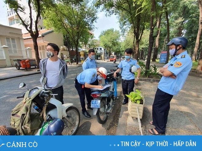 Lực lượng chức năng lập biên bản vì người dân tháo khẩu trang ra ăn sáng /// Ảnh: Kim Qui