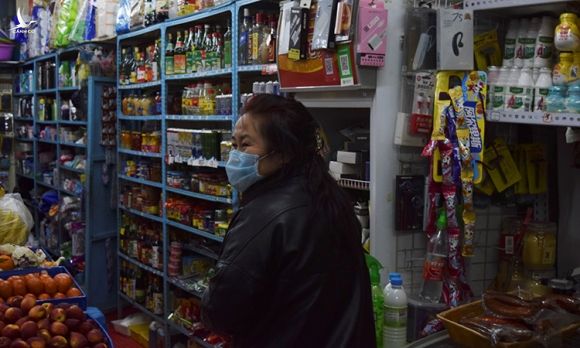 Chủ tiệm tạp hóa ở Tuy Phân Hà đeo khẩu trang tiếp khách hôm 15/4. Ảnh: Reuters.