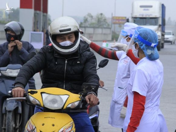 Người đi xe máy qua chốt vào Hải Phòng ở chân cầu Nghìn (H.Vĩnh Bảo) được khai báo y tế, kiểm tra thân nhiệt /// Ảnh: Lê Tân