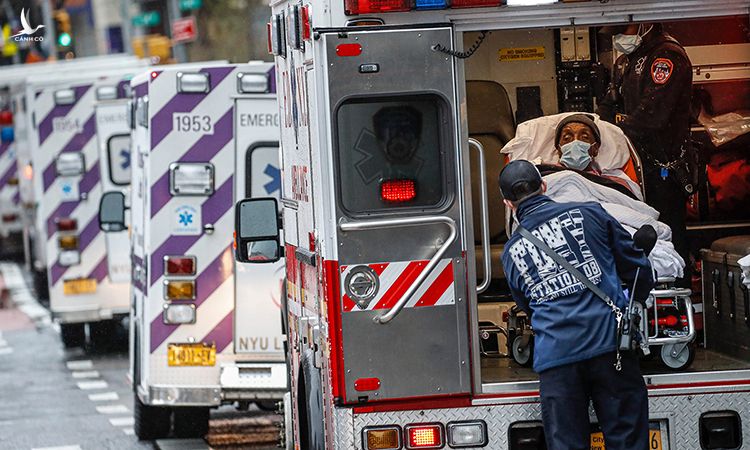 Nhân viên y tế đưa bệnh nhân Covid-19 xuống xe cứu thương bên ngoài Trung tâm Y tế NYU Langone, New York, ngày 13/4. Ảnh: AP.