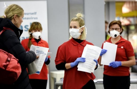 Các nhân viên y tế Phần Lan đeo khẩu trang khi tiếp xúc với du khách từ nước ngoài trở về /// Reuters