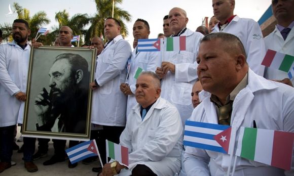 Chuyên gia y tế Cuba chụp ảnh cùng chân dung Fidel Castro trước khi rời Havana sang Italy. Ảnh: AP.