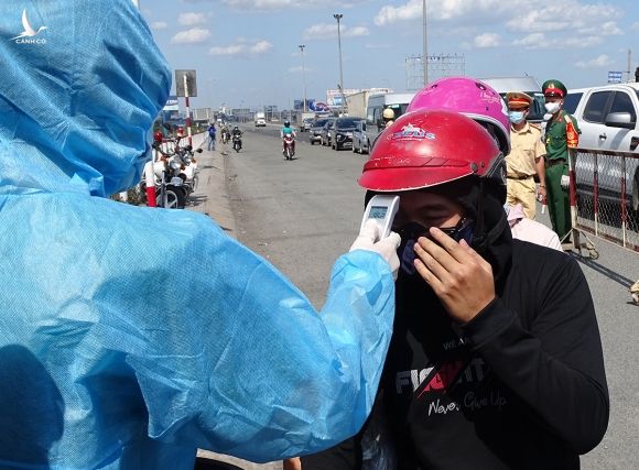 Người đi từ Đồng Nai vào TP HCM phải đo thân nhiệt, nếu không có dấu hiệu bất thường sẽ được đi. Ảnh: Hà An.