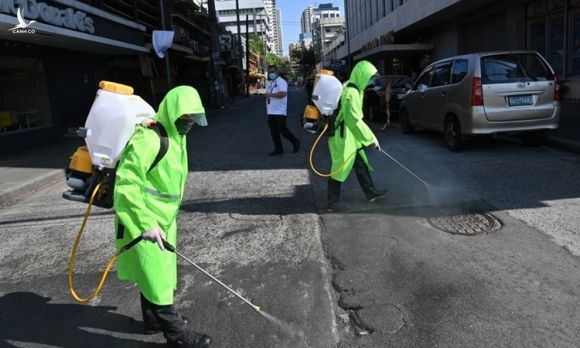 Công nhân mặc đồ bảo hộ phun khử trùng đường phố Manila, Philippines hôm 19/3. Ảnh: AFP.