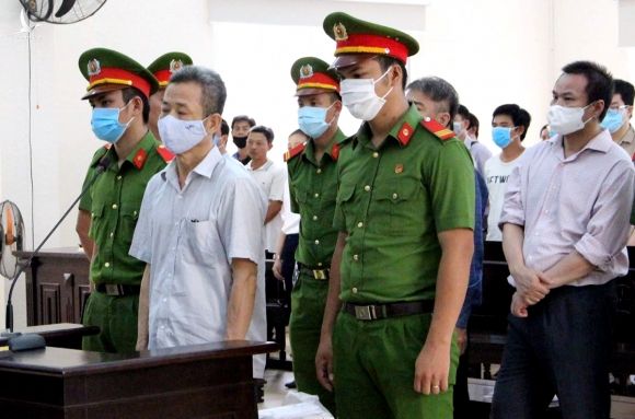 Bị cáo Nguyễn Hồng Khanh (đứng đầu) và lúc tòa tuyên án. Ảnh: Thái Hà.