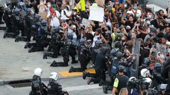 Cảnh sát Atlanta quỳ gối trước người biểu tình hôm 1/6. Ảnh: AP