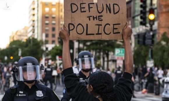 Người biểu tình giơ biểu ngữ cắt giảm ngân sách cho cảnh sát tại thủ đô Washington ngày 1/6. Ảnh: Reuters.
