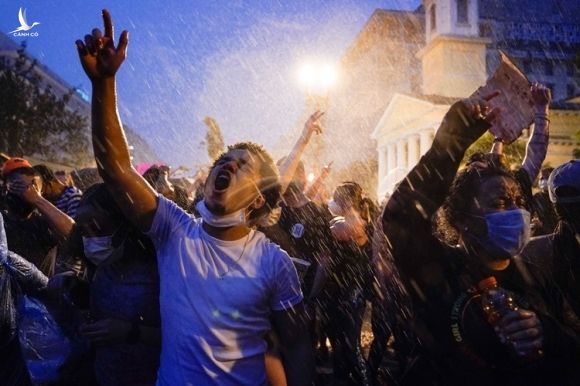 Người dân biểu tình trong mưa lớn ở thủ đô Washington tối 4/6. Ảnh: AP.