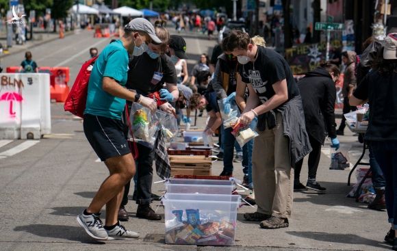 Các tình nguyện viên đóng gói đồ cung cấp cho người vô gia cư trong khu phố. Ảnh: NY Times.