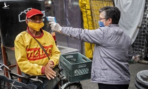 Một người đàn ông được đo thân nhiệt tại khu chợ ở thủ đô Mexico City của Mexico hôm 22/6. Ảnh: AFP.