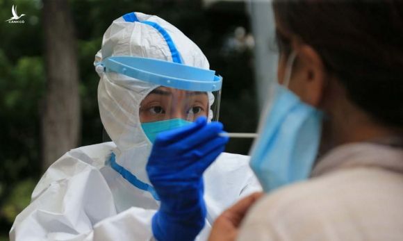Nhân viên y tế lấy mẫu xét nghiệm nCoV tại thành phố Đại Liên, tỉnh Liêu Ninh, Trung Quốc, hôm 26/7. Ảnh: AFP.