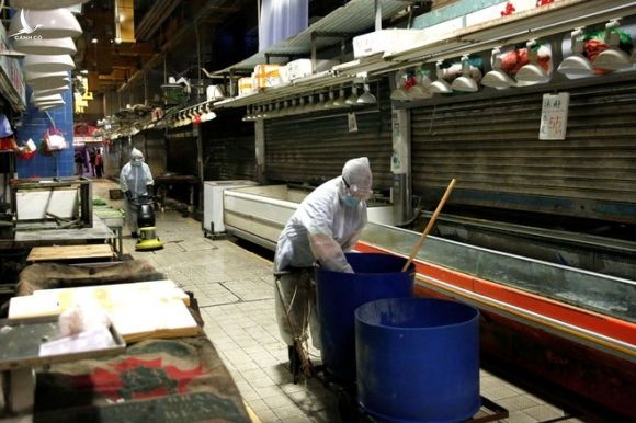 Các nhân viên dọn dẹp, phun khử khuẩn tại một khu chợ ở Hồng Kông /// Reuters