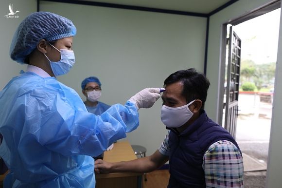 Bác sĩ đo thân nhiệt cho bệnh nhân tại Hà Nội tháng 3/2020. Ảnh: Ngọc Thành