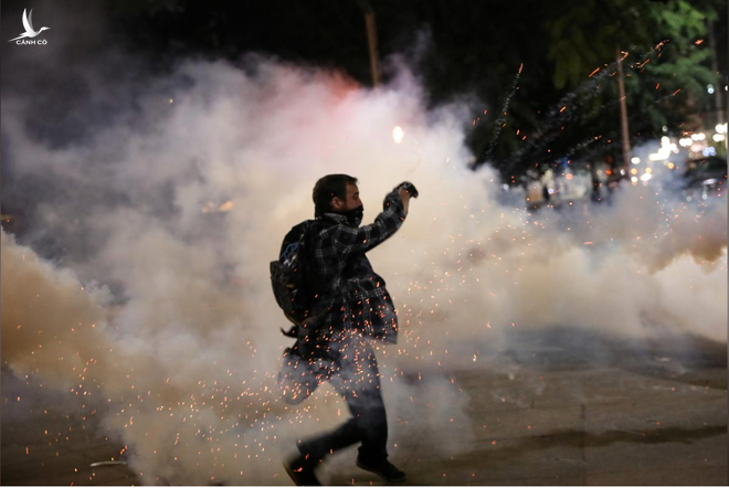 Một người biểu tình ném trả lựu đạn cay về phía cảnh sát tại TP.Portland, bang Oregon /// Reuters