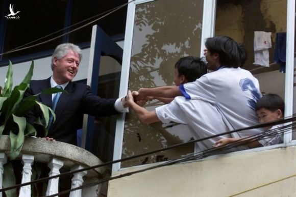 Tổng thống Mỹ Bill Clinton (trái) bắt tay người dân Việt Nam từ ban công một tòa nhà đối diện Văn Miếu - Quốc Tử Giám, Hà Nội tháng 11/2000. Ảnh: AP.