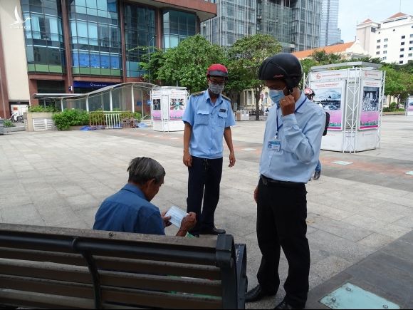 Một người vô gia cư không có khẩu trang được phát miễn phí tại phố đi bộ Nguyễn Huệ, quận 1. Ảnh: Hà An.