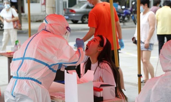 Nhân viên y tế lấy mẫu xét nghiệm nCoV tại thành phố Đại Liên, tỉnh Liêu Ninh, hôm 27/7. Ảnh: AFP.