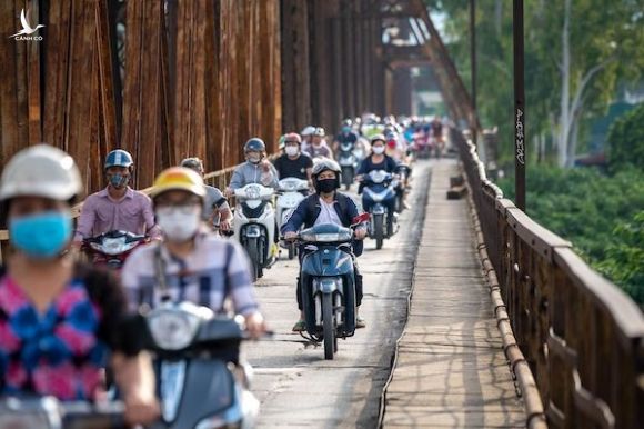 Người dân đi xe máy trên cầu Long Biên, Hà Nội. Ảnh: Bloomberg.