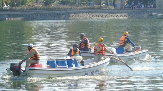 Công nhân Công ty Thoát nước HN dùng chế phẩm Redoxy-3C xử lý ô nhiễm ở hồ Nghĩa Tân /// Ảnh Lê Quân 