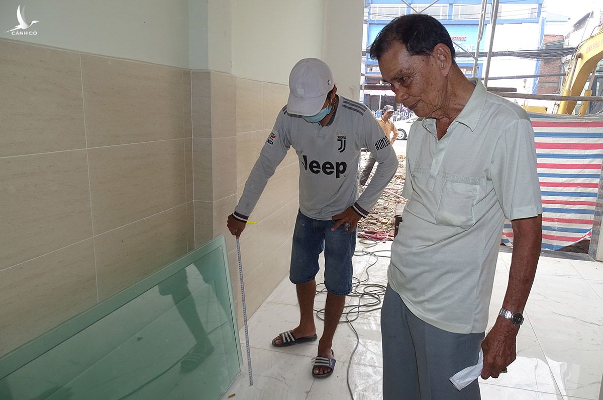 Ông Trần Văn Đức đang cùng thợ sửa nhà sau khi bàn giao mặt bằng cho dự án Metro Số 2, ngày 12/9. Ảnh: Hà An.