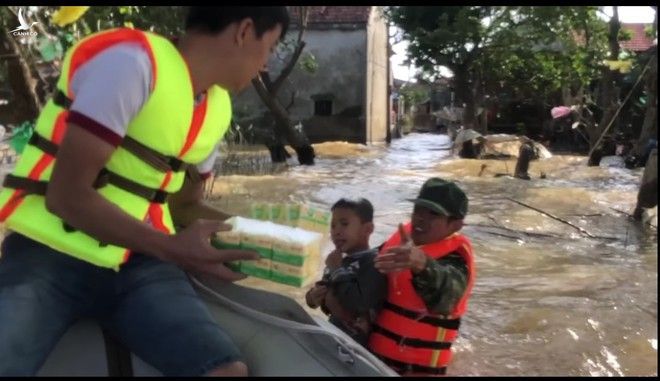 Cháu bé liều mình bơi giữa dòng nước lũ để nhận cứu trợ /// Ảnh cắt từ clip