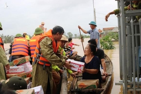 Người dân lội nước ngập sát cổ đi nhận hàng cứu trợ ở Quảng Bình