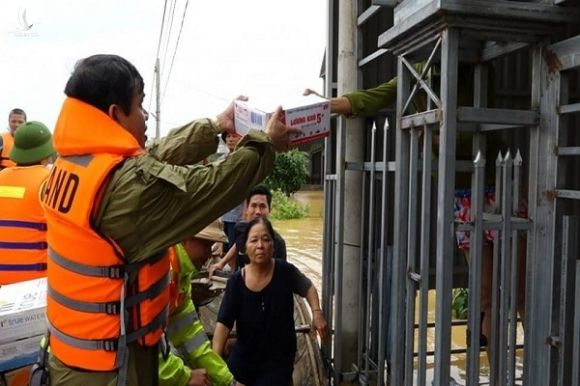 Người dân lội nước ngập sát cổ đi nhận hàng cứu trợ ở Quảng Bình