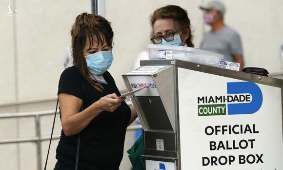 Một nữ cư tri đứng trước điểm bỏ phiếu sớm ở Miami, bang Florida hôm 19/10. Ảnh: AP.
