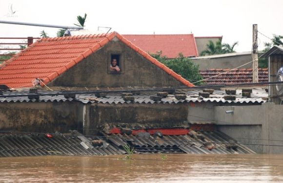 Nước ngập sâu, người dân tỉnh Quảng Bình chỉ biết leo lên nóc nhà để trốn. /// ẢNH: MẠNH CƯỜNG