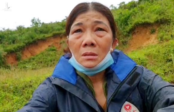 Bà Lê Hà Thị Dung ngồi bệt bên đường khóc, xem nhà chức trách tìm thi thể con rể. Ảnh: Táo Hoàng