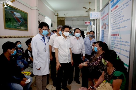 Phó Thủ tướng Vũ Đức Đam nói chuyện với người dân đến khám bệnh tại Phòng khám đa khoa Vạn An, TP Tân An, tỉnh Long An. Ảnh: Đình Nam